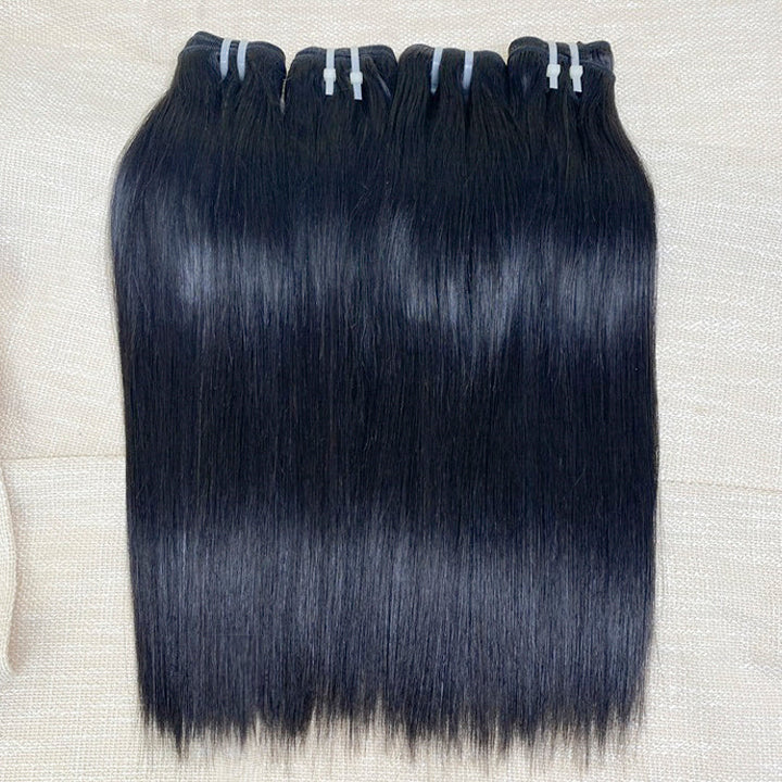 Three bundles of straight black human hair extensions laid out on a surface.
