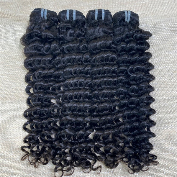 Three bundles of deep wave raw human hair extensions laid out on a surface.