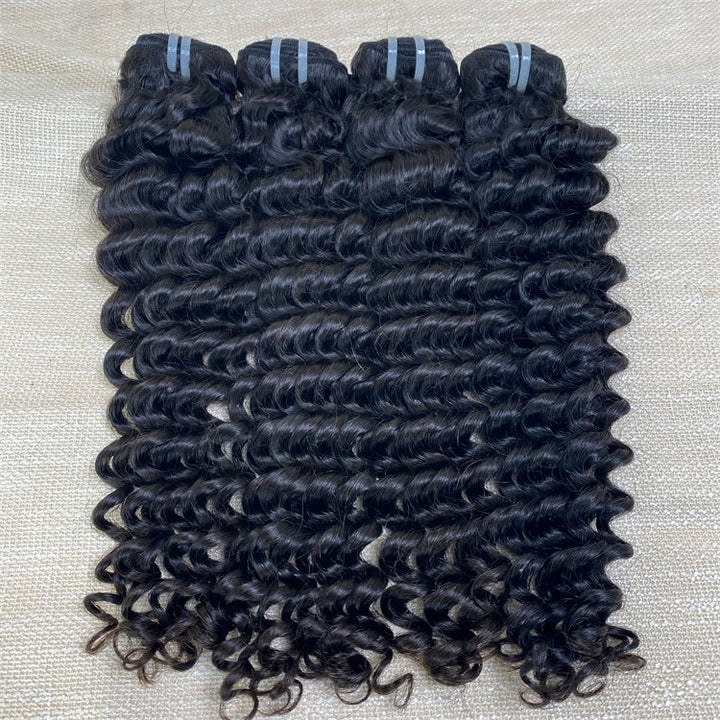 Three bundles of deep wave raw human hair extensions laid out on a surface.