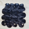 Three bundles of XBLhair Flawless Raw Hair hair extensions with body wave texture, laid out on a surface.