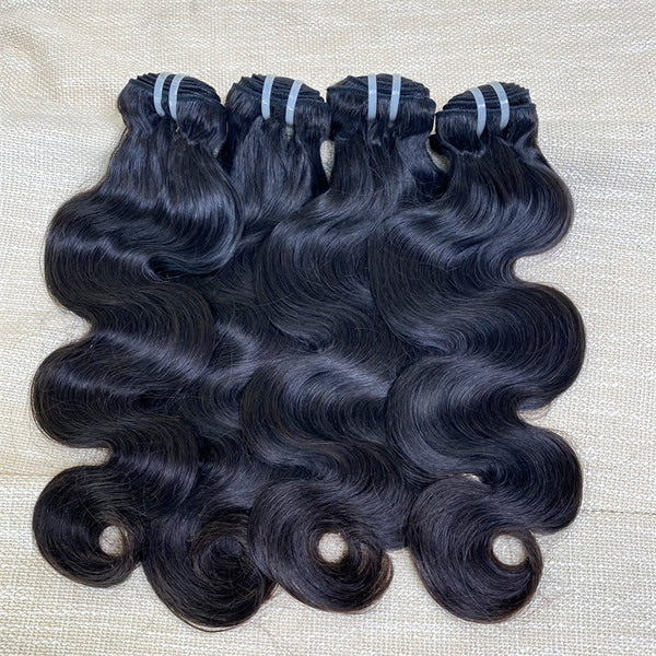 Three bundles of XBLhair Flawless Raw Hair hair extensions with body wave texture, laid out on a surface.