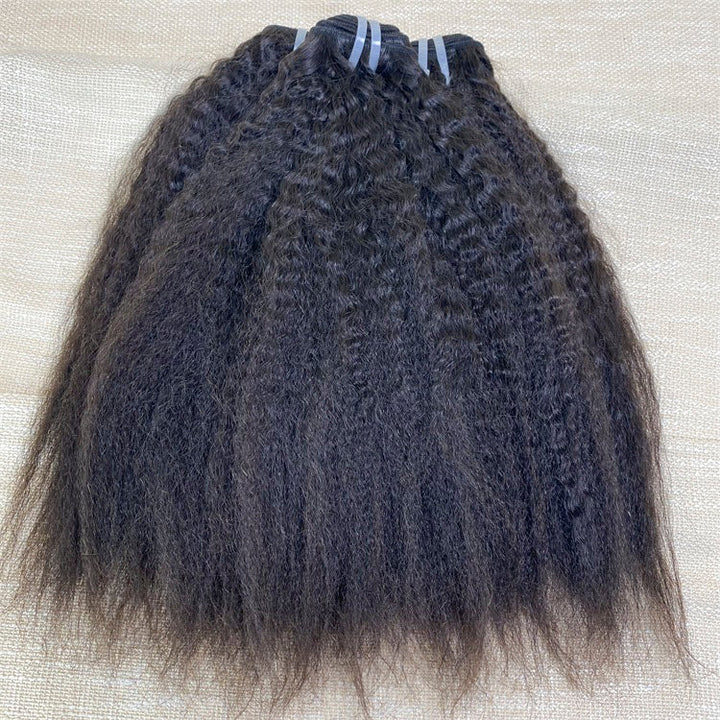 A bundle of kinky straight, black Vietnam human hair extensions laid out on a surface.