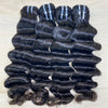 Three pieces of loose deep human hair extensions laid out on a surface, with visible natural curl and texture.